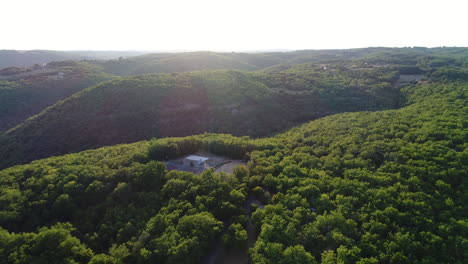 Outdoor-sports-field-in-the-middle-of-a-forest-by-drone.-Sunset-time